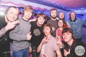 large group of mostly men wearing silent disco headphones